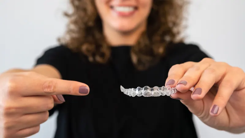 Person holding a clear aligner tray